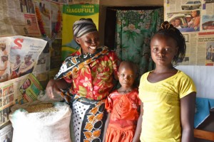 Valeria and her daughters and part of their bountiful maize harvest from ‘ngamia’ seed. B. Wawa/CIMMYT’