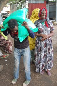 Boti Decheso helps Demetu Edao carry maize seed received through the emergency seed project back to their farms. Photo: E.Quilligan/CIMMYT